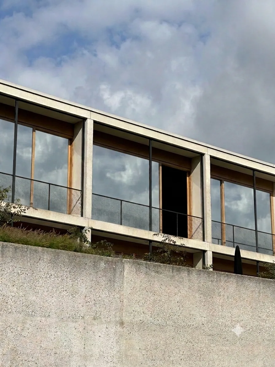 La même façade après pose du miroir sans tain : le vitrage renvoie le ciel