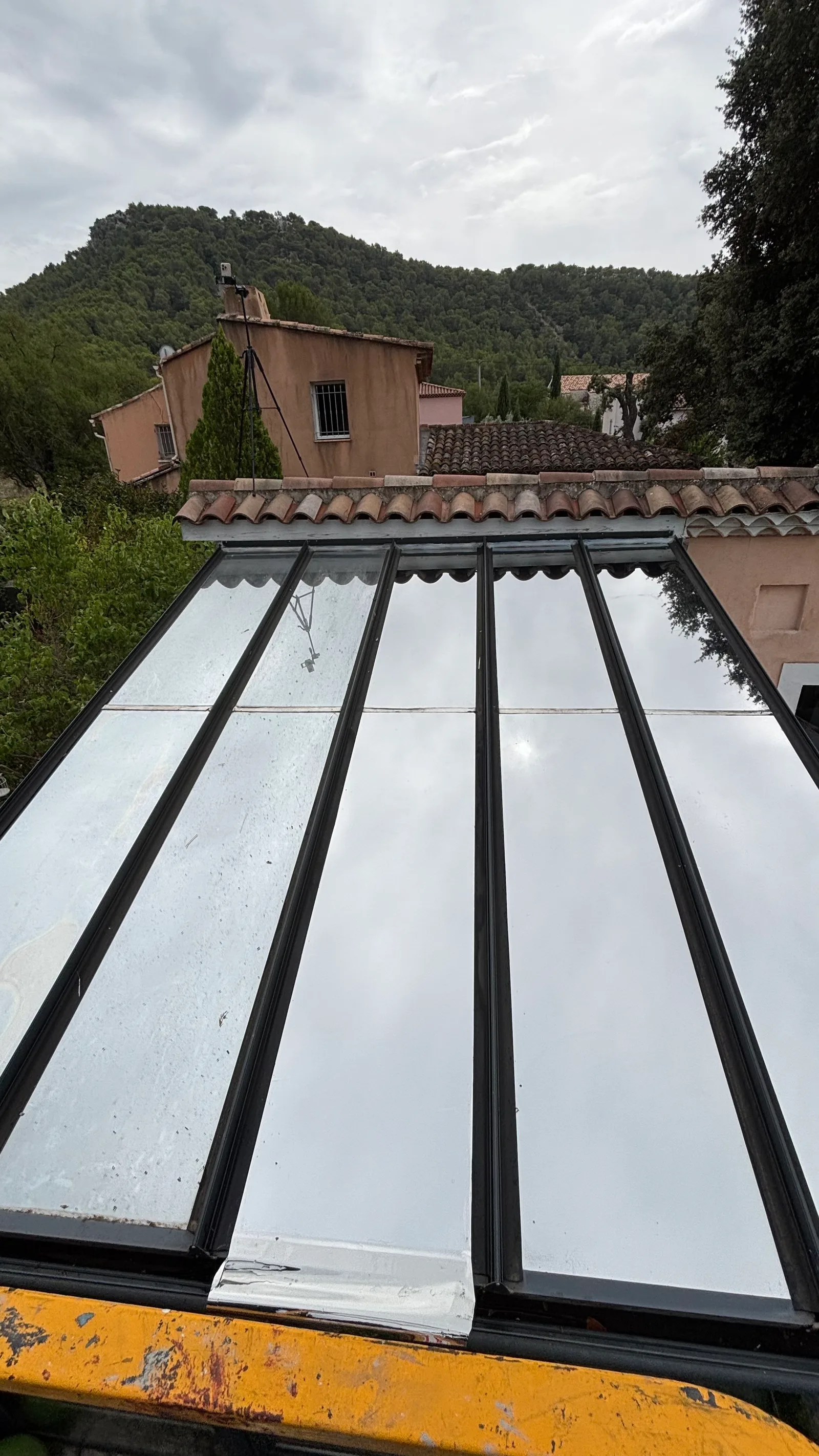 Deux techniciens PrivTeint en nacelle araignée posant un film solaire sur la toiture vitrée d'une véranda dans le Var